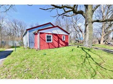 View of the home with red and blue siding sitting on a green lawn at 3142 N Euclid Ave, Indianapolis, IN 46218