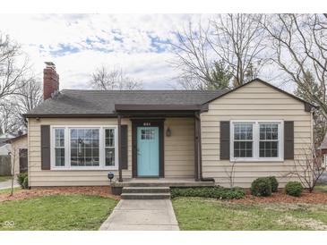 Charming single-story home featuring a bright blue front door and a cozy covered porch at 631 E 86Th St, Indianapolis, IN 46240