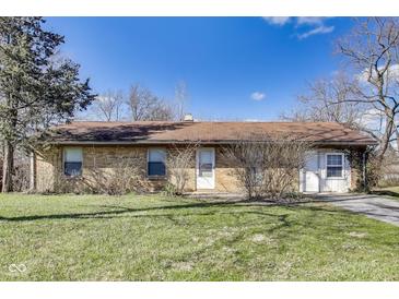 Cozy one-story home featuring a brick facade, mature trees, and a well-manicured lawn at 7906 E 21St St, Indianapolis, IN 46219