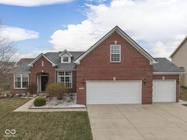 Charming brick home featuring a three-car garage, well-manicured landscaping, and a welcoming front entrance at 834 Bristle Lake Dr, Brownsburg, IN 46112