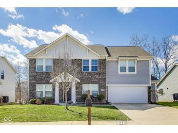 Inviting two-story home boasts a brick facade, manicured lawn, and attached two-car garage at 8610 Fawn Way, McCordsville, IN 46055