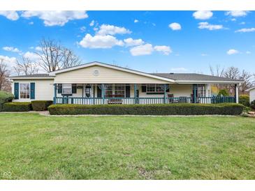 Charming single-story home boasts a well-manicured lawn and inviting front porch with rocking chairs at 9255 W 30Th St, Indianapolis, IN 46234