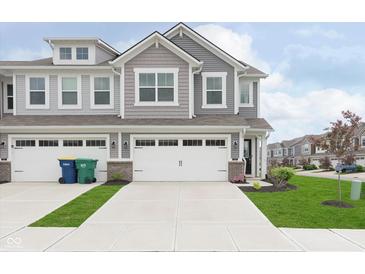 Charming two-story townhome with gray siding, a two-car garage, and a well-manicured lawn at 1239 Newton St, Avon, IN 46123