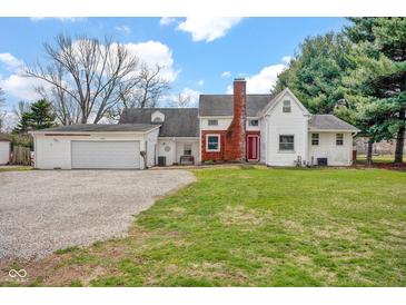 Charming home with a red front door, brick accents, and a spacious two-car attached garage at 1707 Rocky Ford Rd, Columbus, IN 47203