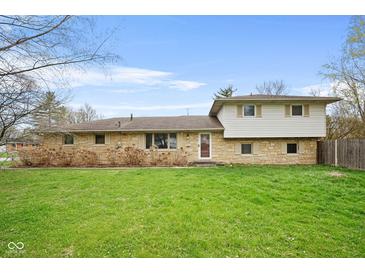 Charming home featuring a well-maintained lawn and a unique stone and siding facade at 4108 Carson Ave, Indianapolis, IN 46227