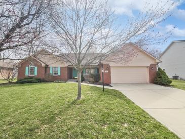 Charming single-story home with a well-manicured lawn and attached two car garage at 603 Raintree Dr, Avon, IN 46123