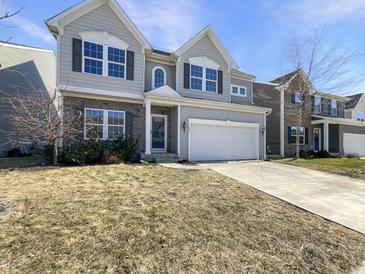 Charming two-story home with gray siding, stone accents, well-manicured lawn, and attached garage at 733 Keepsake Run, Greenwood, IN 46143