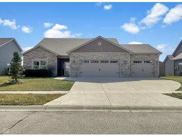Charming single story home featuring stone accents, three car garage and well manicured lawn at 943 Foxglove St, Lebanon, IN 46052
