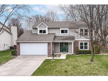 Charming two-story home featuring a well-maintained lawn, attached two-car garage, and welcoming front entrance at 12527 Trester Ln, Fishers, IN 46038