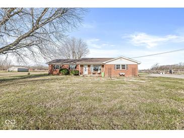 Charming single-story brick home with a well-maintained front lawn and beautiful landscaping under a clear blue sky at 1636 N County Road 425 E, Avon, IN 46123