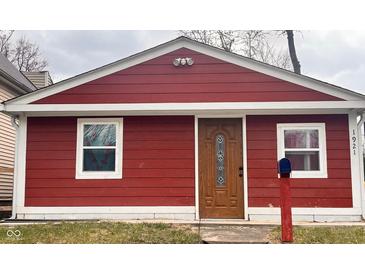 Charming single-story home with a red exterior, a decorative front door and well-maintained landscaping at 1921 W Michigan St, Indianapolis, IN 46222