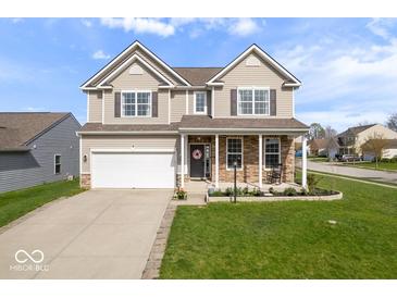 Charming two-story home with a well-manicured lawn and a two car garage and covered porch at 15152 Fallen Leaves Ln, Noblesville, IN 46060