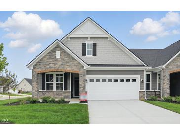 Charming single-story home featuring stone and gray siding, a two-car garage, and manicured lawn at 16955 Cole Evans Dr, Noblesville, IN 46060