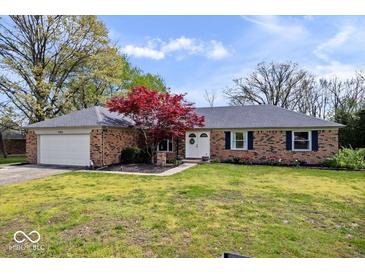 Charming brick home featuring a well-manicured lawn, beautiful landscaping, and an attached two-car garage at 7263 Hidden Valley Dr, Plainfield, IN 46168