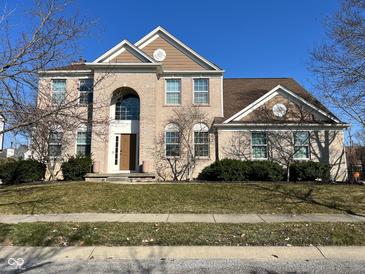 Beautiful brick two-story home with a well-manicured lawn and blue sky at 8259 Plumwood Ln, Indianapolis, IN 46256