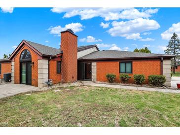 Charming single-story brick home with a well-manicured lawn and inviting entryway at 9242 Golden Leaf Way, Indianapolis, IN 46260
