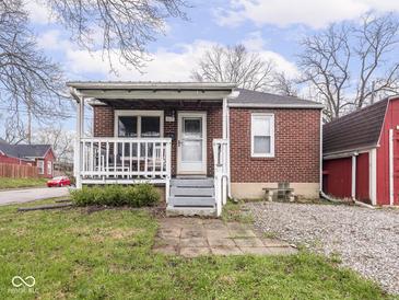 Charming brick home featuring a welcoming porch and a well-maintained front yard at 1237 E Pleasant Run Pkwy S Dr, Indianapolis, IN 46203