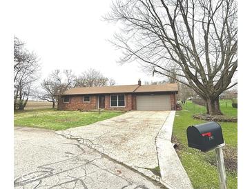 Charming single-story brick home with a two-car garage and long driveway at 1761 Country Lane Dr, Greenfield, IN 46140