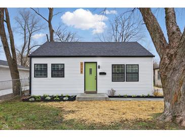 Charming home featuring a new roof, fresh white siding, black trim and a bright green front door at 3105 N Tacoma Ave, Indianapolis, IN 46218