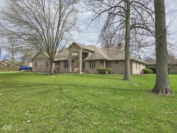 Charming single-story brick home featuring mature trees and a well-manicured lawn at 4808 N Camelot Dr, Muncie, IN 47304