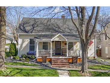 Charming home featuring a quaint front porch, brick stairs, and beautifully landscaped front yard at 490 W Walnut St, Zionsville, IN 46077