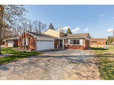 Charming single-story home featuring a brick facade, attached garage, and well-maintained front yard with mature trees at 6340 Bluebell Ct, Indianapolis, IN 46224