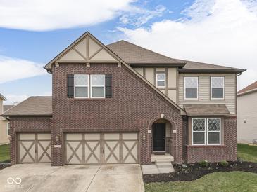 Charming two-story home featuring a brick facade, arched entryway, and a spacious two-car garage at 7730 Imperial Eagle Dr, Zionsville, IN 46077