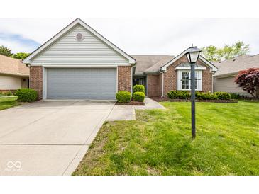 Charming brick home with a well-maintained lawn and attached two-car garage, complemented by a classic-style lamp post at 8737 Champions Dr, Indianapolis, IN 46256