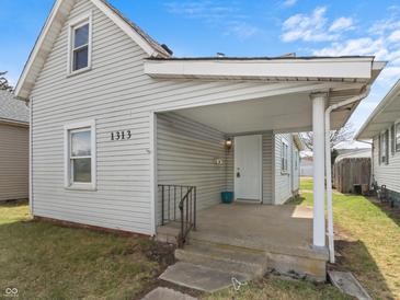 Charming single-Gathering home featuring a covered front porch, light gray siding, and a well-maintained lawn at 1313 W Memorial Dr, Muncie, IN 47302