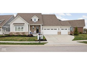 Charming single-Gathering home with manicured lawn, three-car garage, and welcoming front porch at 15250 Mooring E Cir, Carmel, IN 46033