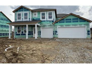 Two-story home featuring a two-car garage and a covered porch, awaiting its finishing touches in a new development at 211 Ames Dr, Whiteland, IN 46184