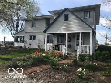 Charming home with a well-maintained lawn, lovely flowerbeds, and a welcoming front porch at 3030 N 600 E, Lebanon, IN 46052