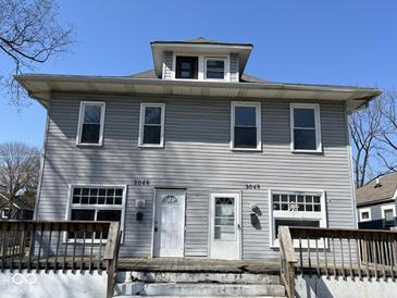 Two-story home featuring a gray exterior and a porch with railing at 3046 Central Ave, Indianapolis, IN 46205