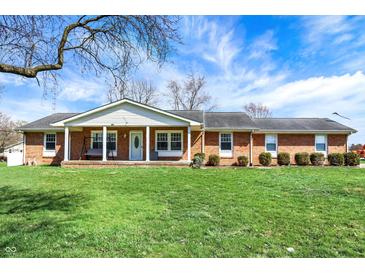 Inviting brick home with a charming front porch and well-manicured lawn at 3940 E 600 N, Columbus, IN 47203