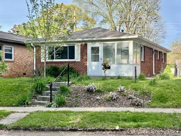 Charming brick home with a cozy sunroom, white trim, and a well-manicured front yard at 4151 Bowman Ave, Indianapolis, IN 46227