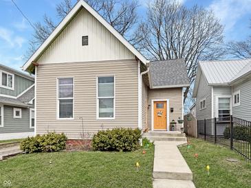 Charming home featuring a neat front yard and a brightly colored front door at 430 Parkway Ave, Indianapolis, IN 46225