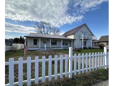 Charming two story home featuring a covered porch, white picket fence, and a classic architectural style at 529 E Jackson St, Martinsville, IN 46151