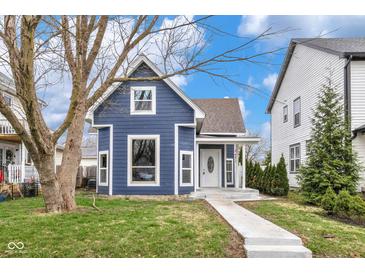 Charming blue two-story home featuring a welcoming front porch and a well-maintained lawn at 555 N Hamilton Ave, Indianapolis, IN 46201