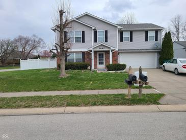 Charming two-story home with a well-manicured lawn, lovely landscaping, and inviting entrance at 7497 Grandview Dr, Avon, IN 46123