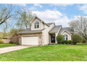 Charming two-story home features a manicured lawn and attached two car garage at 10516 Beacon Ln, Indianapolis, IN 46256