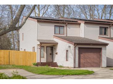 Two-story condo with vinyl siding, a single car garage and solar panels on the roof at 1512 Tipton Ln, Columbus, IN 47201