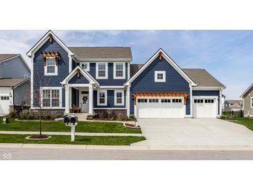 Stunning two-story home with blue siding, white trim, manicured lawn, and a spacious three-car garage at 15679 Woodford Dr, Westfield, IN 46074
