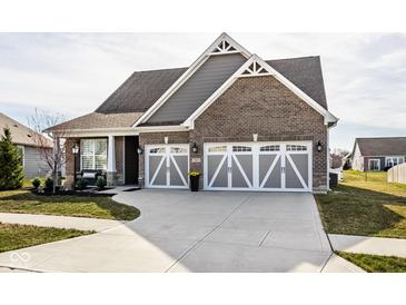 Charming home with a two-car garage, brick facade, grey siding, and a well-manicured front lawn at 3849 Sun Valley Dr, Westfield, IN 46074