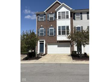 Charming brick townhome featuring a two-car garage and beautiful blue shutters at 9454 Tanhurst Dr, Indianapolis, IN 46250