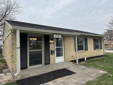 Charming single-story home with light yellow brick, black shutters and covered porch at 1502 Saint John S Ct, Beech Grove, IN 46107