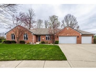 Charming brick home featuring an attached garage and a beautifully manicured lawn at 1550 Renee Dr, Plainfield, IN 46168