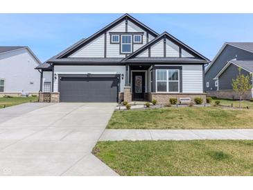 Charming home featuring a gray exterior, two-car garage, well-maintained lawn, and inviting front entrance at 15755 Scher Dr, Westfield, IN 46074