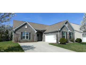 Charming single-Gathering home features a well-manicured lawn, a two-car garage, and blossoming trees in the front yard at 1630 Valdarno Dr, Greenwood, IN 46143