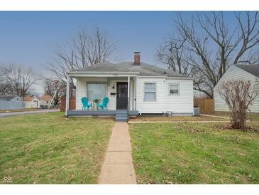 Charming single-story home featuring a cozy front porch with cheerful turquoise chairs at 1957 N Colorado Ave, Indianapolis, IN 46218