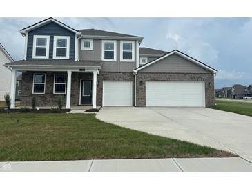 Two-story home boasts a two-car garage, gray brick accents, covered porch, and manicured front yard at 240 Ames Dr, Whiteland, IN 46184